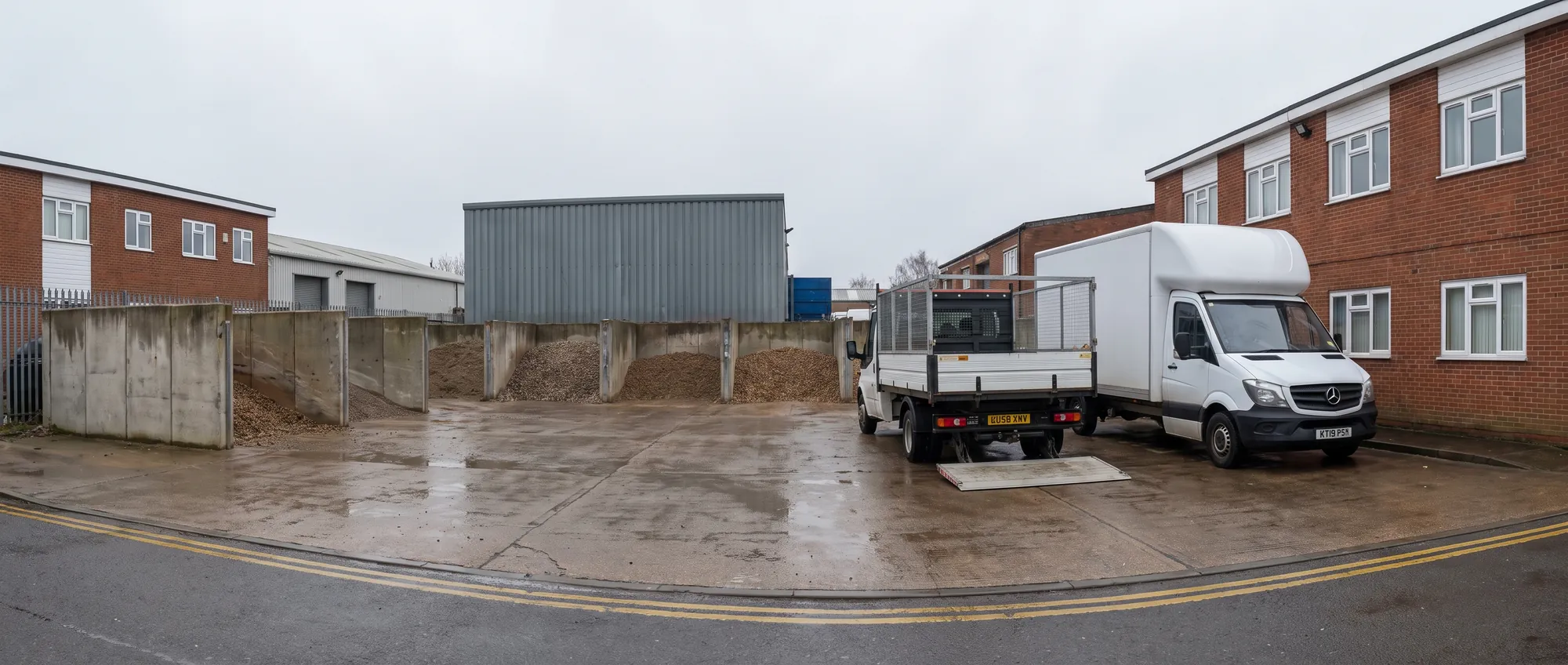 A cage tipper and a Luton van parked side by side at the yard with their tails down